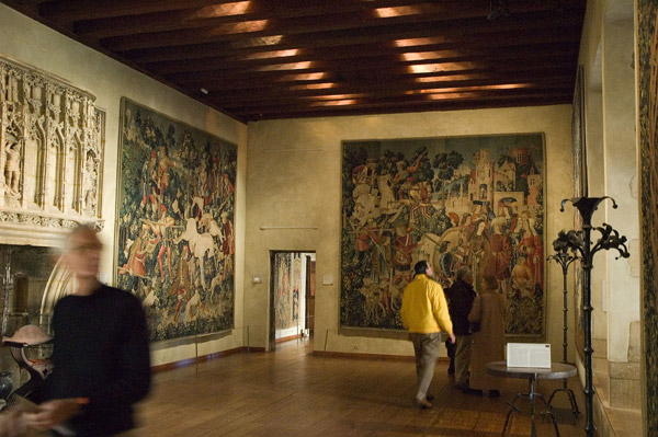 Visitors walk through a museums's room of renaissance
tapestries.