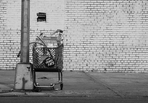 A shopping cart on the street proclaims an odd
product.