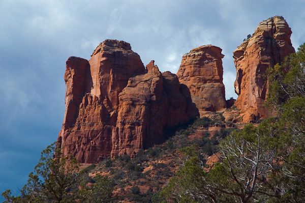 A group of red mesas stands out against a blue sky.