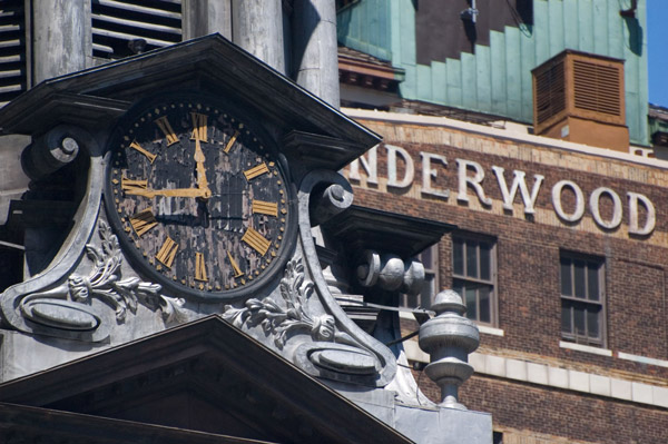 A black, weathered clock face stands out against background
buildings.