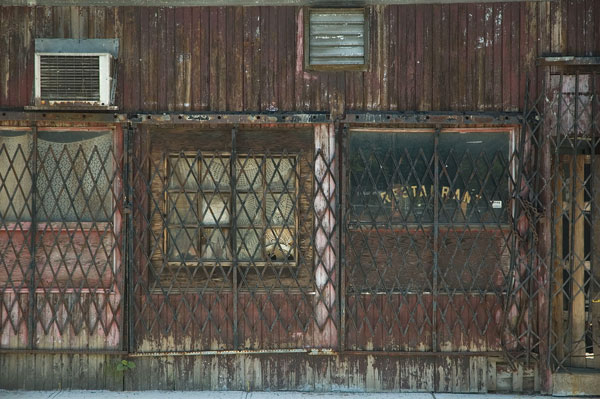 Gates cover a sooty, wooden-sided old restaurant.