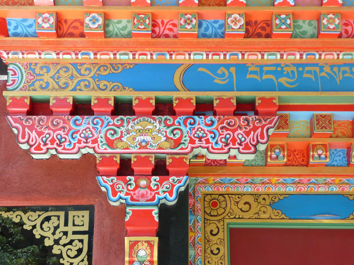 A variety of bright colors and patterns on detailed
wood above a restaurant entrance.