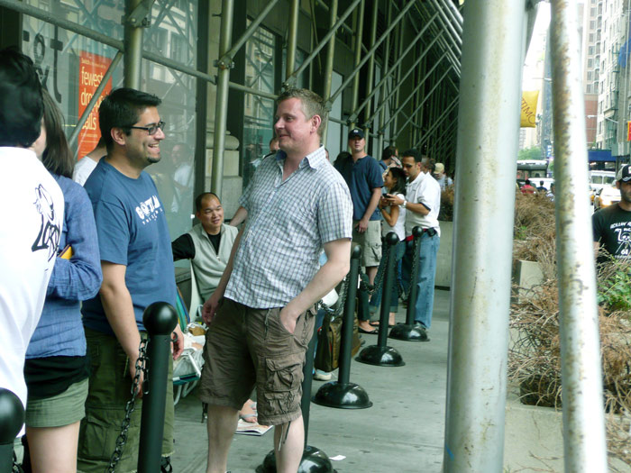 People laugh as they wait in line for Apple's iPhone.
