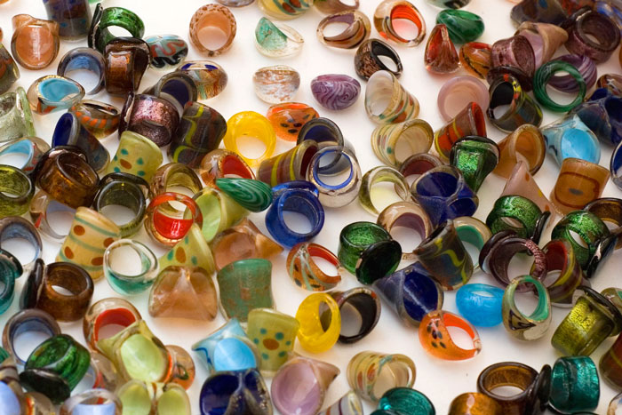 Multi-colored acrylic rings are scattered on a white table.