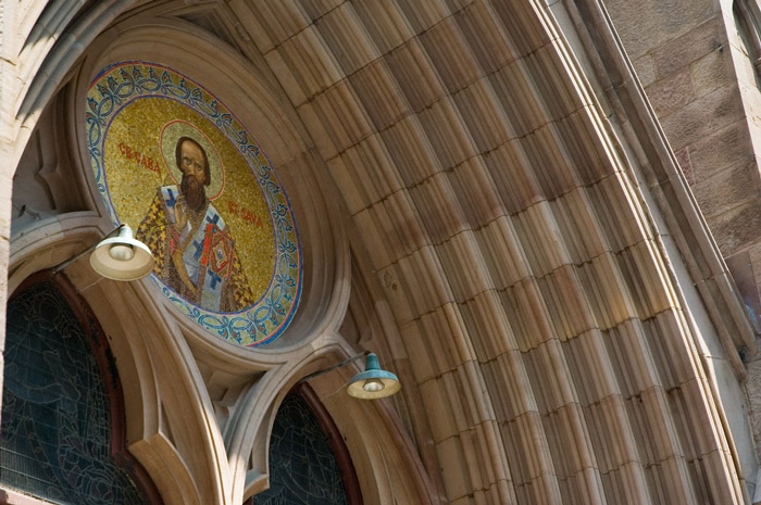 A saint's portrait is at the top of an arched entrance.