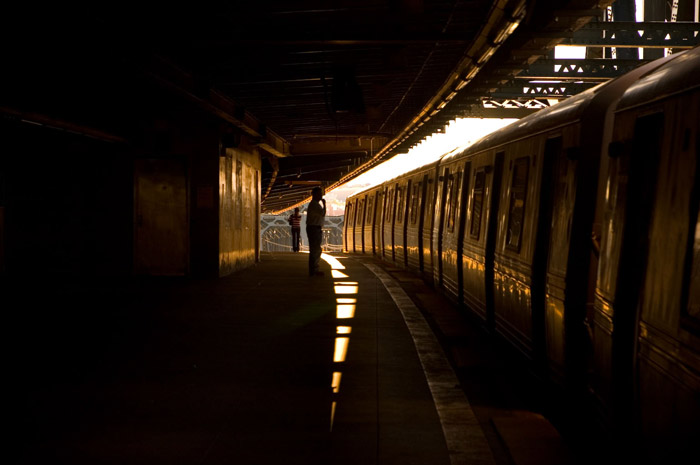 Light wedges through shadows between platform and train.