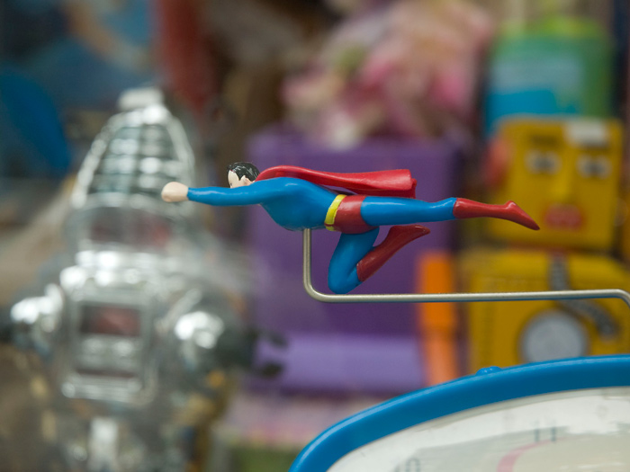 A Superman figure is suspended above a child's clock.