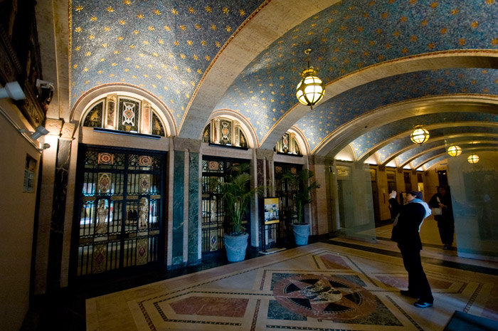 A building's lobby consists of several arched sections, each decorated with tiled gold stars on a field of blue.
