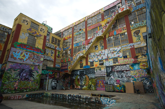 The outside of a large building has been given over to graffiti artists, and scores have decorated it in bright colors and images.