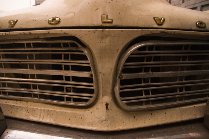 The photo shows the grille of an old Volvo, with many dents, pockmarks, and spots of rust.