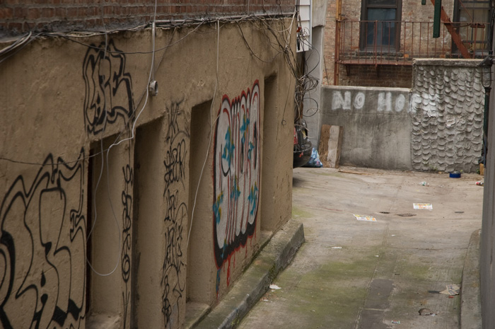 Someone has spray painted the words 'No Hope' on a wall at the end of an alley.