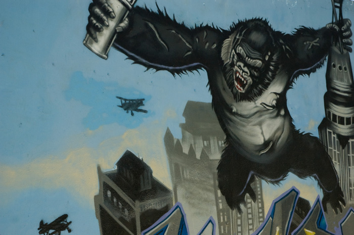 A wall mural shows King Kong with a can of spray paint, fighting off planes as he hangs on the Empire State Building.