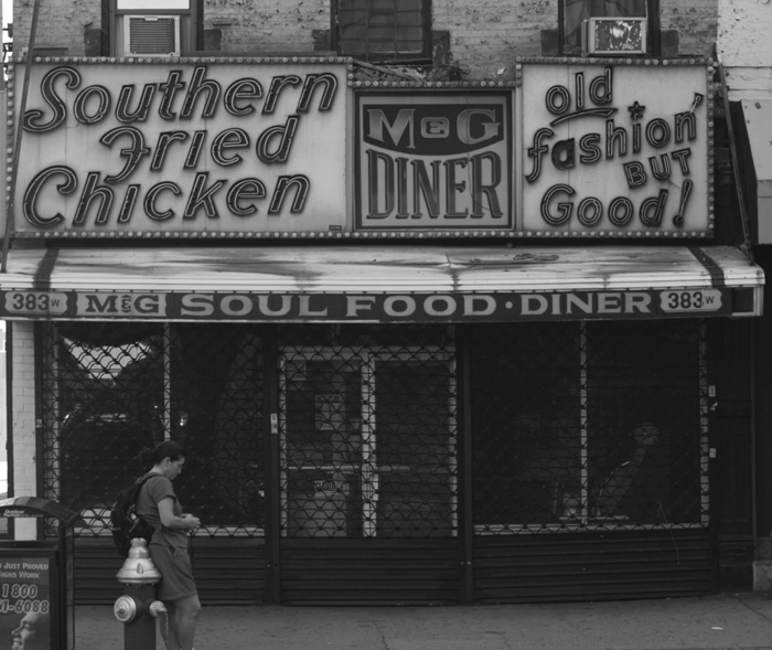 The unlit neon of a closed diner advertises southern fried chicken and old fashinoned food.