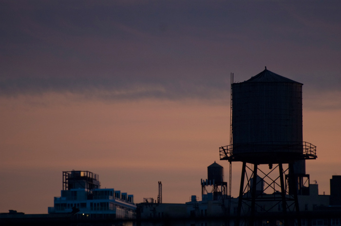 A water tank stands out against purple skies.