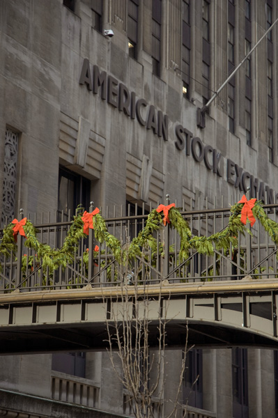 Garlands of pine branches, decorated with red bows, have been strung on a pedestrian walkway by the American Stock Exchange.