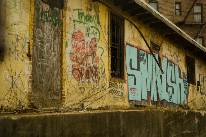 A row of abandoned loading docks is covered with graffiti.