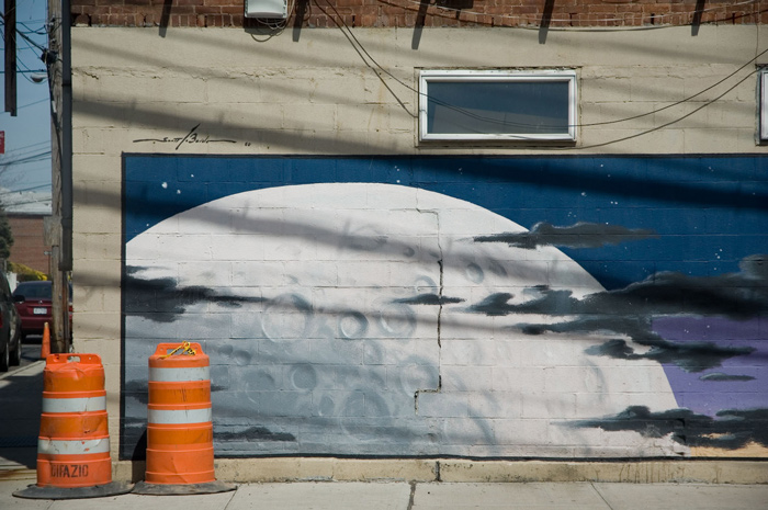 The side of a building has been painted with a moonscape.