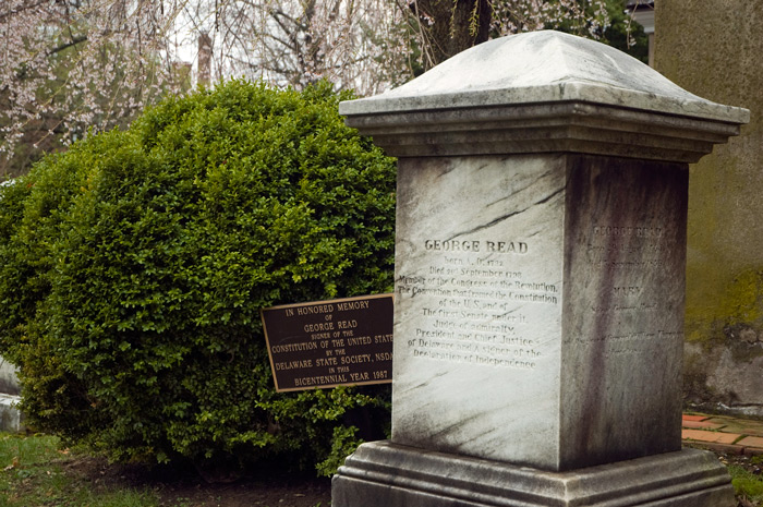 A pillar over a grave is inscribed with a historical summary of George Read.