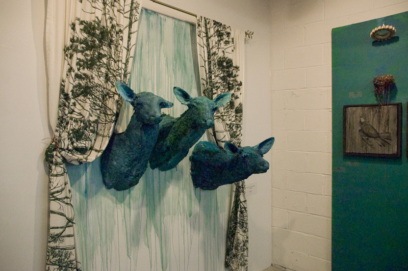 Art, consisting of three teal colored deer heads coming in through a curtained window.