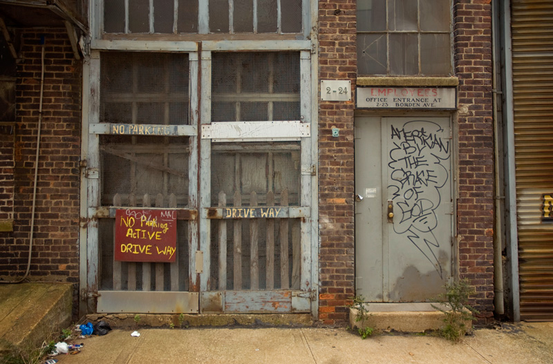 The phrase 'American By The Grace of God' has been scrawled on an industrial building door.