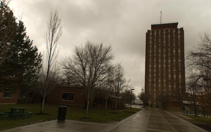 A tall building rises over a plaza on a dreary day.