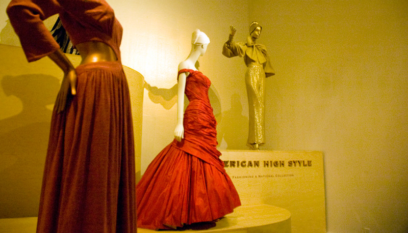 Three high-fashion dresses, on mannequins.