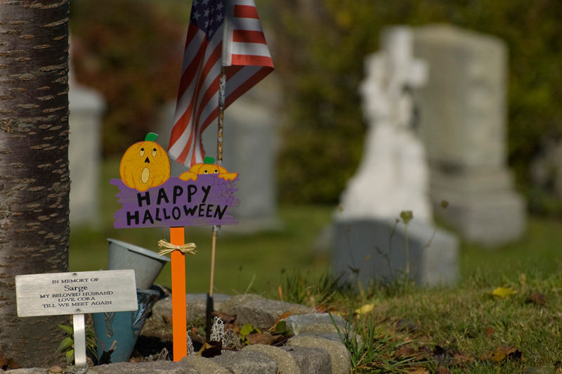 Halloween decorations next to a grave.