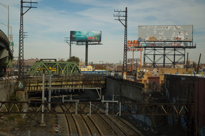 A billboard for Mexico tourism, over train tracks and overpasses.