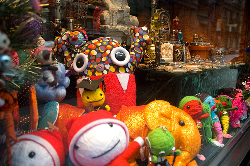 Colorful, stuffed, cartoonish figures in a store window.