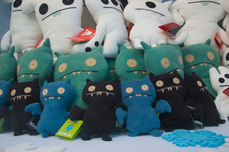 Ugly dolls in winter colors, in a winter setting in a storefront.