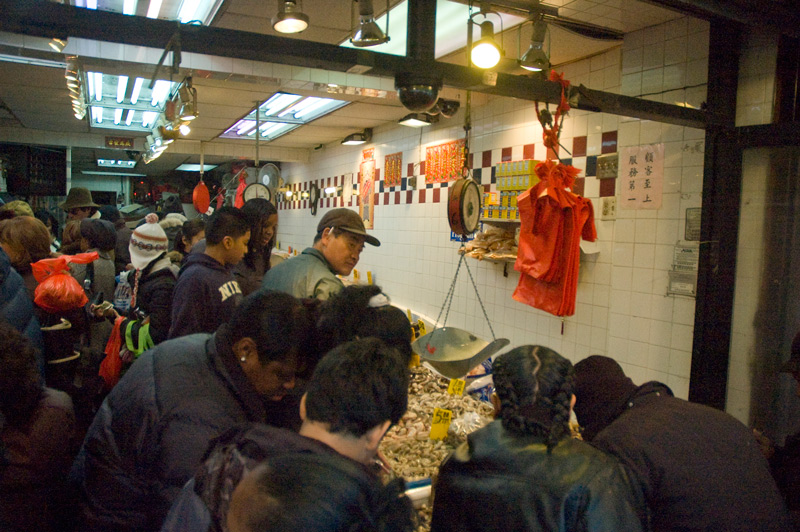 A fish market with crowds of customers.