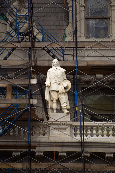 A statue of Peter Stuyvesant, on a building ledge.