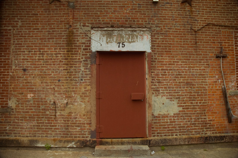 A red steel door in a brick wall.