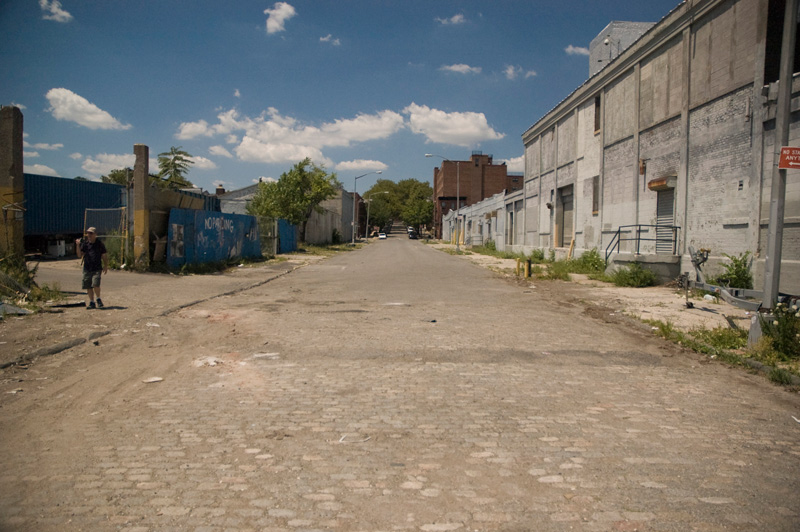 A bleak, empty industrial street on a bright, hot day.