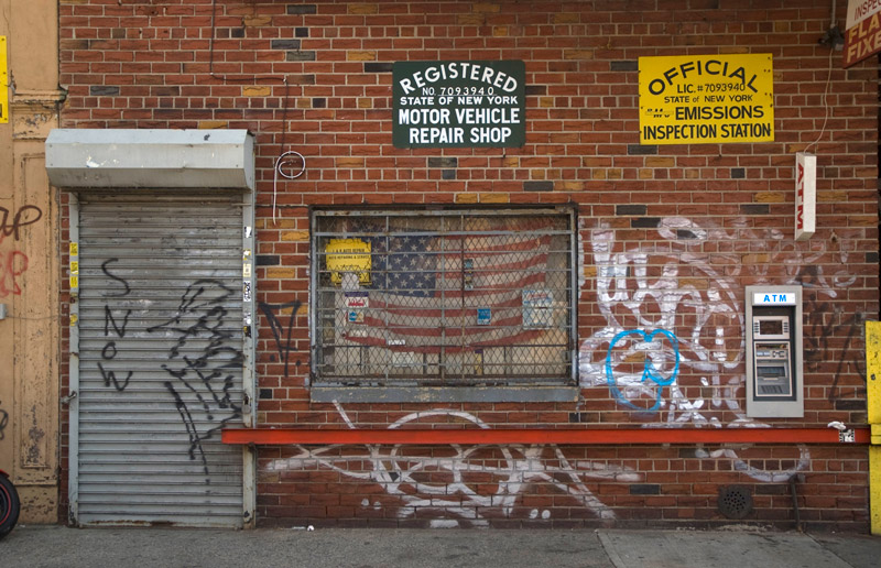 An auto repair shop with a flag in its window