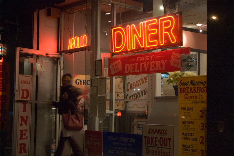 A customer exiting a diner at night.
