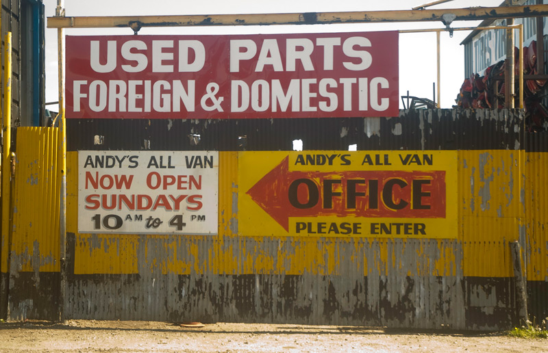 A red, yellow, and black sign advertising auto parts