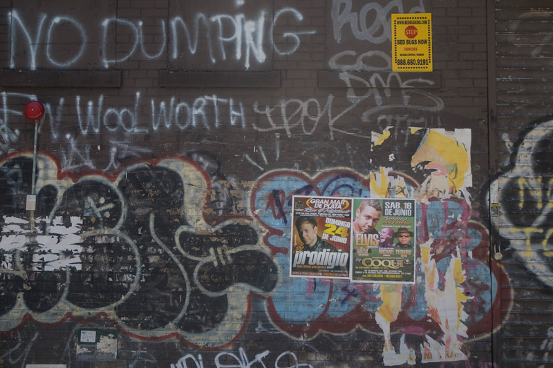 An ugly wall, covered with graffiti and an order against dumping.