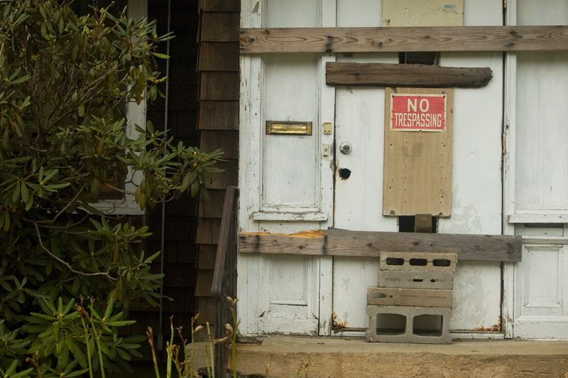 Barricaded entrance to a home, with a 'No Trespassing' sign.