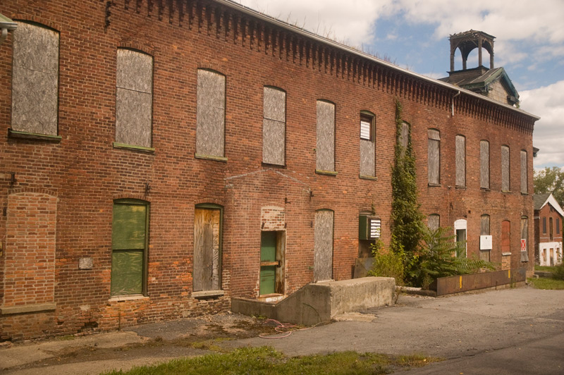 A large brick building with boarded-up windows.