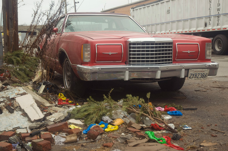 A red Pontiac Thurnderbird, parked next to debris.