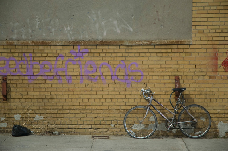 A bike parked against a wall with graffiti