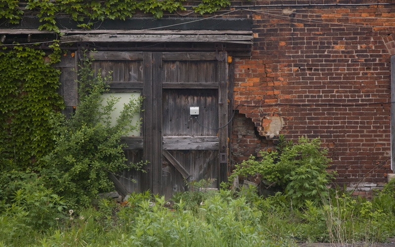 A wooden double door on an old brick building