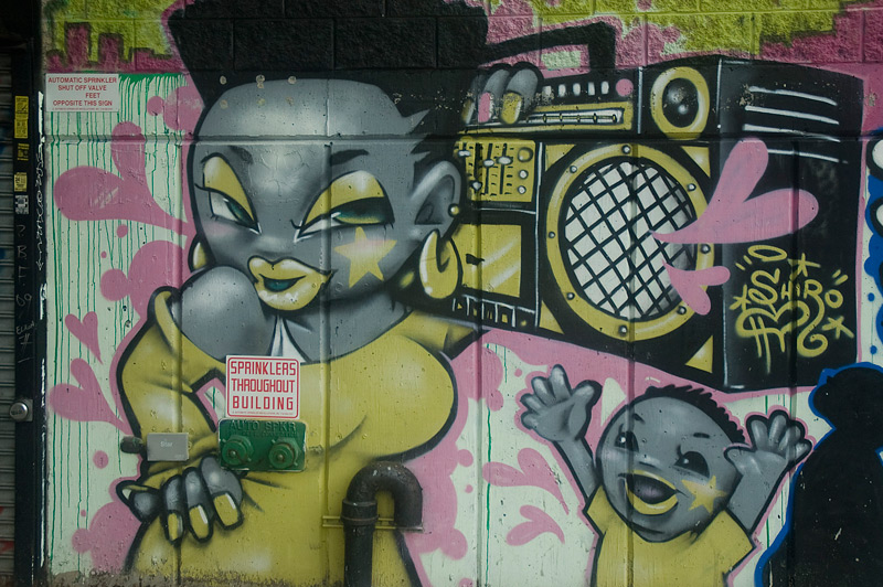 Cartoonish mural showing a child reaching for a woman's boombox.
