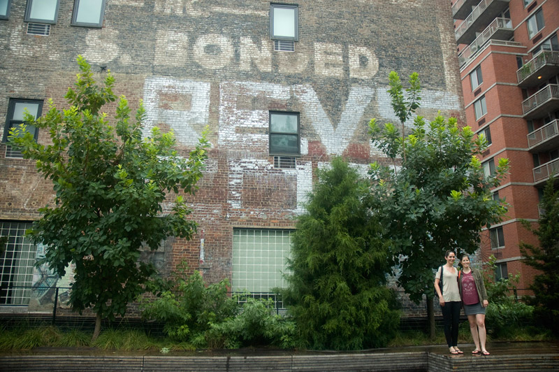 Two tourists pose in front of Revs graffiti.