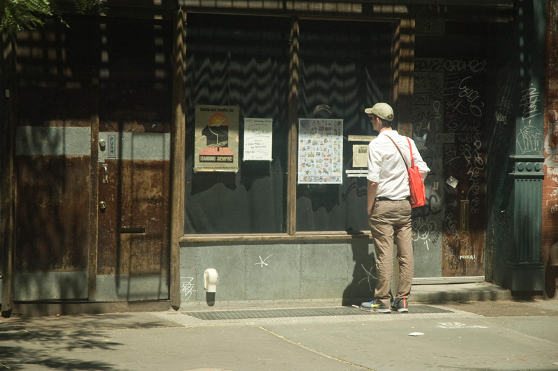 A man reads advertisements on a window.