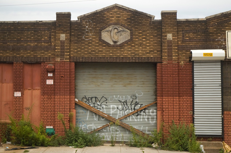 An old garage, with tire and wing emblem.