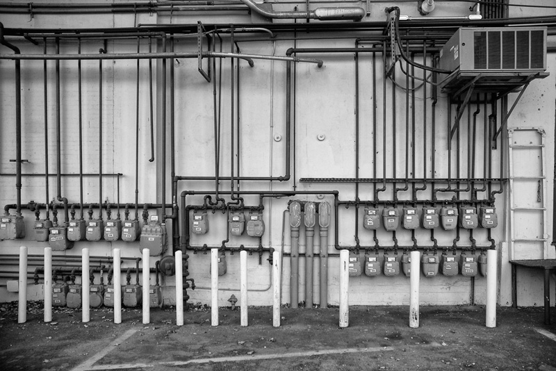 Many gas meters on a wall.