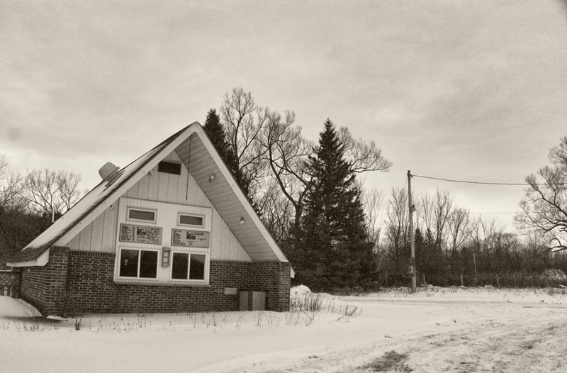 A burger shack, closed, with snow.