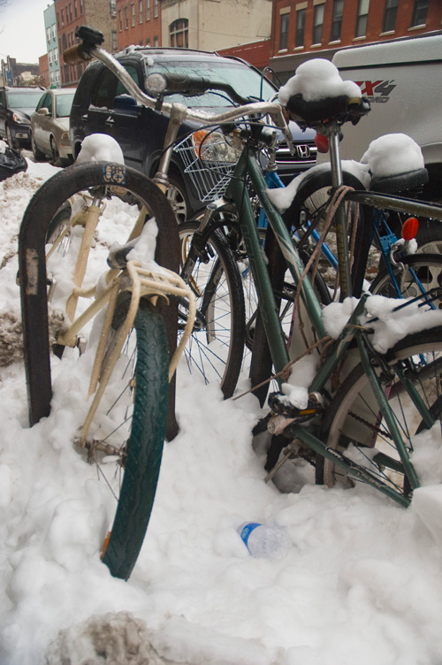 Bicycles covered in snow.